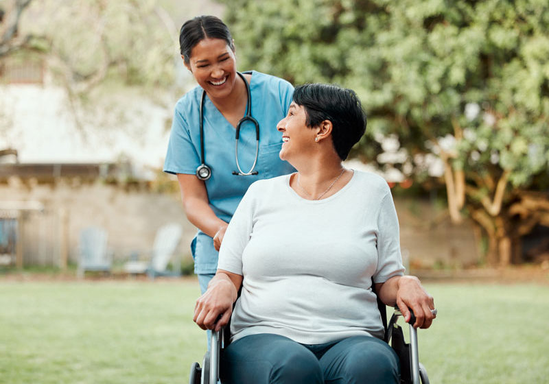 Nurse-pushing-a-woman-in-a-wheelchair